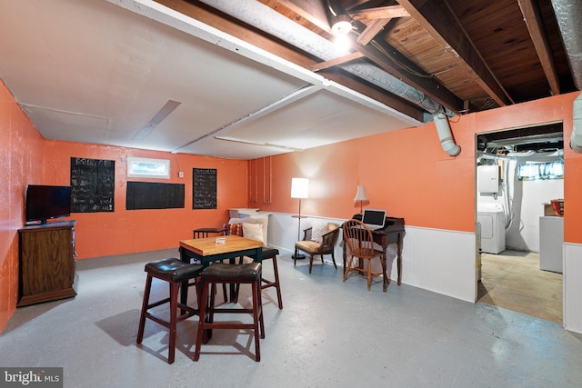 dining area with washer / dryer, a wainscoted wall, and concrete floors