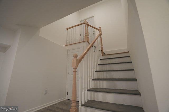 stairway featuring wood finished floors and baseboards