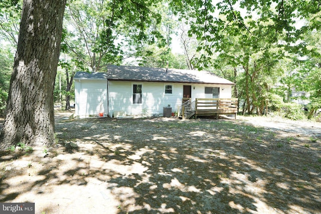 rear view of property with a wooden deck and cooling unit