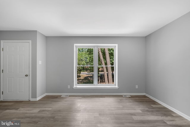 unfurnished room with baseboards and wood finished floors