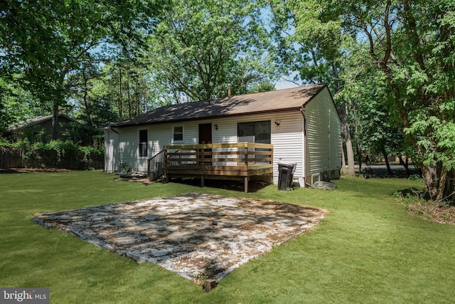 rear view of property with a deck and a lawn