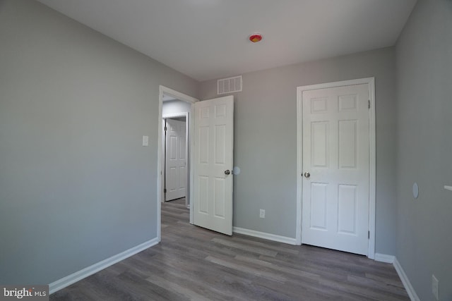 unfurnished bedroom with baseboards and wood finished floors