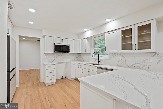 2144 Silentree Dr, Vienna, VA 22182 - kitchen featuring light stone counters, decorative backsplash, recessed lighting, glass insert cabinets, and white cabinetry