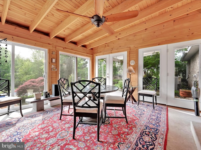 dining room with beam ceiling, wooden ceiling, wood walls, and ceiling fan
