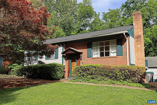 1024 Cottonwood Rd, Charlottesville, VA 22901 - view of front of home featuring brick siding, a chimney, a front yard, a shingled roof, and central AC
