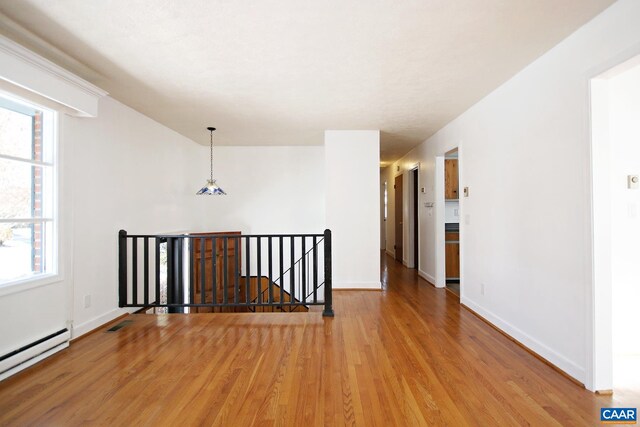 1024 Cottonwood Rd, Charlottesville, VA 22901 - empty room with a baseboard radiator, wood finished floors, and plenty of natural light