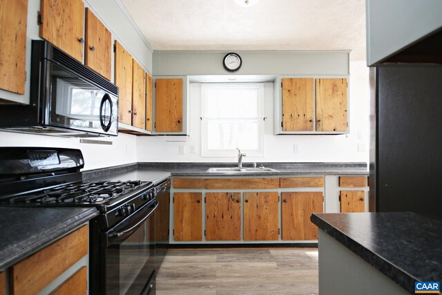 1024 Cottonwood Rd, Charlottesville, VA 22901 - kitchen featuring black appliances, a sink, dark countertops, light wood-style flooring, and brown cabinetry