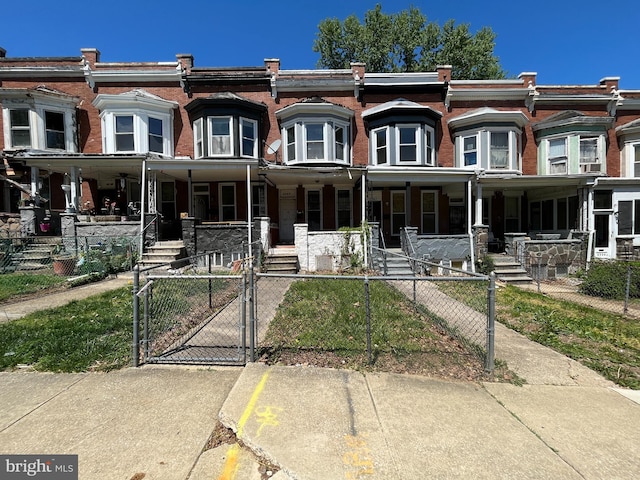 2742 W Mosher St, Baltimore, MD 21216 - townhome / multi-family property with covered porch, a gate, and a fenced front yard