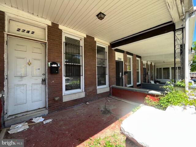 2742 W Mosher St, Baltimore, MD 21216 - doorway to property with a porch and brick siding