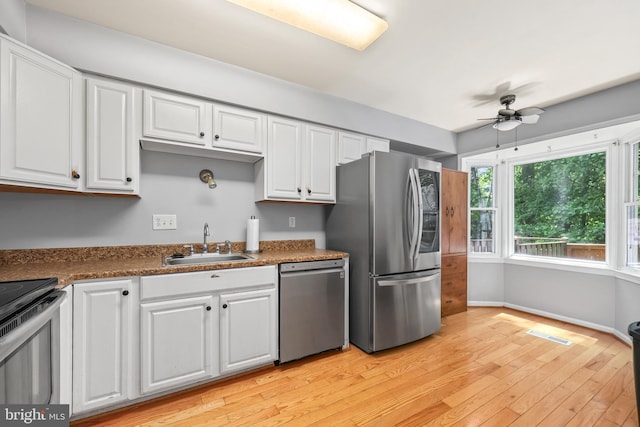 4439 Starling Ct, Woodbridge, VA 22193 - kitchen with stainless steel appliances, a sink, a ceiling fan, light wood finished floors, and white cabinetry