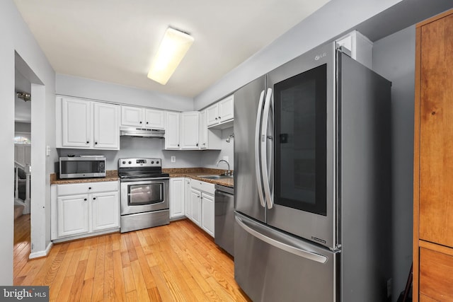 4439 Starling Ct, Woodbridge, VA 22193 - kitchen with stainless steel appliances, under cabinet range hood, white cabinets, light wood-style floors, and a sink