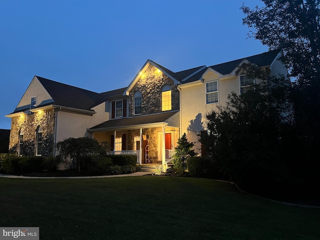 114 Saint Augustine Ct, Middletown, DE 19709 - traditional-style home featuring stone siding, covered porch, a front yard, and stucco siding