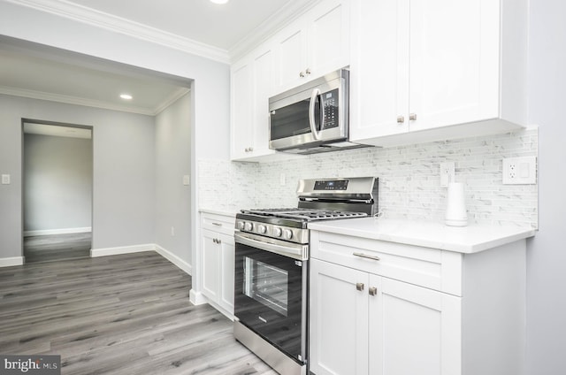 4915 78th Ave, Hyattsville, MD 20784 - kitchen featuring stainless steel appliances, ornamental molding, light wood finished floors, light countertops, and white cabinets