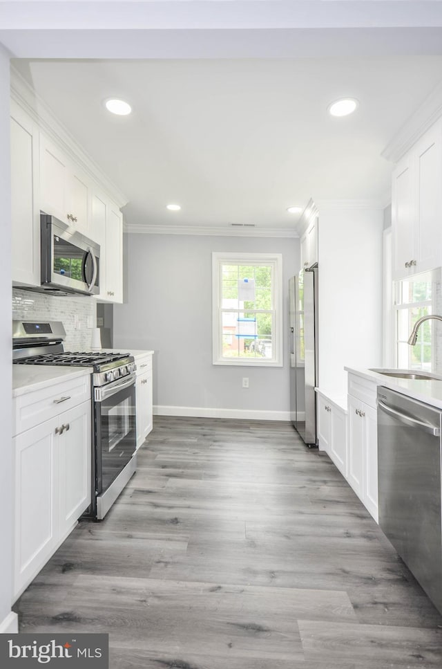 4915 78th Ave, Hyattsville, MD 20784 - kitchen featuring stainless steel appliances, a sink, ornamental molding, recessed lighting, and white cabinetry