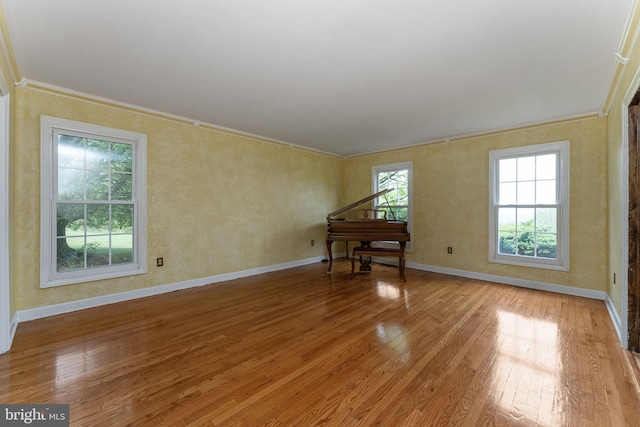 unfurnished room featuring ornamental molding, light wood finished floors, and baseboards