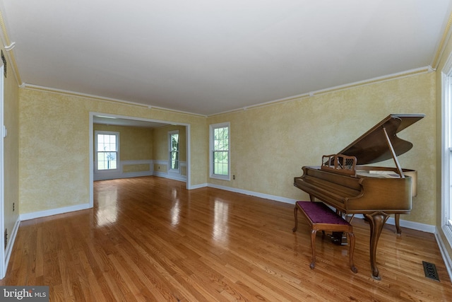 sitting room with crown molding, wood finished floors, and baseboards