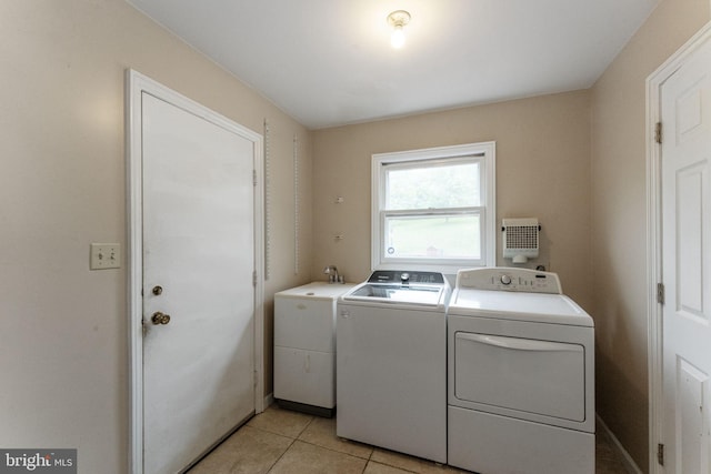 laundry room featuring washing machine and dryer and light tile patterned flooring