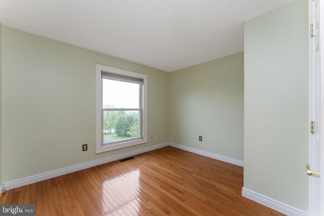 unfurnished room with light wood-style flooring and baseboards