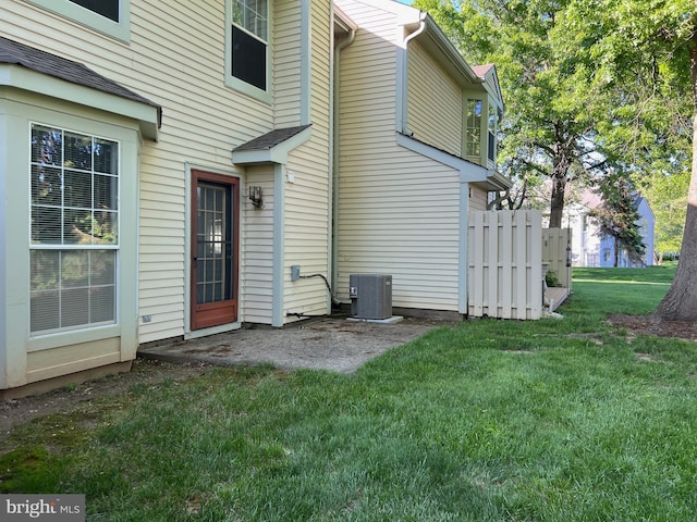 doorway to property with central AC and a yard