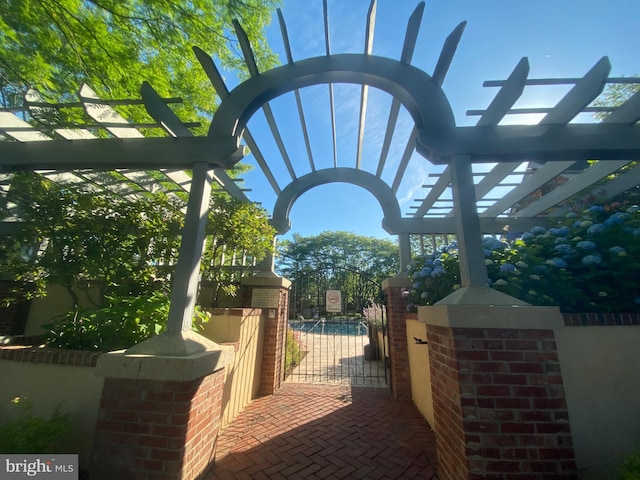 view of property's community with a gate and a pergola