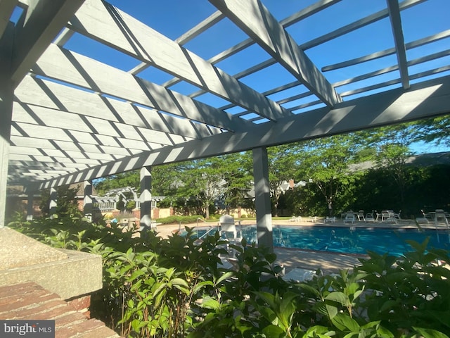 community pool with a pergola and a patio area