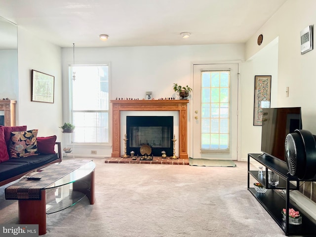 living room featuring a glass covered fireplace, carpet flooring, and plenty of natural light