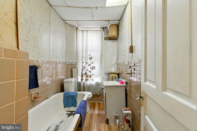 1625 6th St NW, Washington, DC 20001 - bathroom with tile walls, a bath, wood finished floors, a paneled ceiling, and toilet
