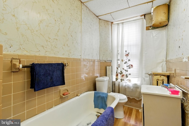 1625 6th St NW, Washington, DC 20001 - full bathroom with tile walls, toilet, vanity, a tub, and wood finished floors