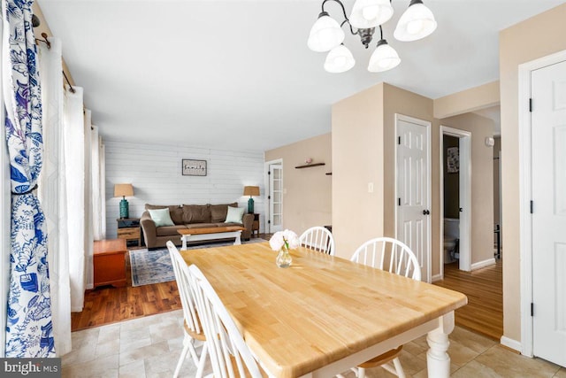 105 Bachtell Cir, Smithsburg, MD 21783 - dining space featuring a chandelier, baseboards, wood walls, and light wood finished floors