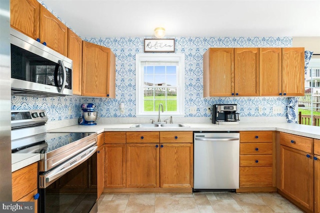 105 Bachtell Cir, Smithsburg, MD 21783 - kitchen featuring appliances with stainless steel finishes, a sink, light countertops, brown cabinets, and wallpapered walls