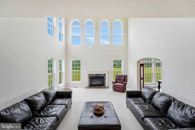42506 Black Talon Ct, Leesburg, VA 20176 - living area with arched walkways, carpet flooring, a high ceiling, and a fireplace