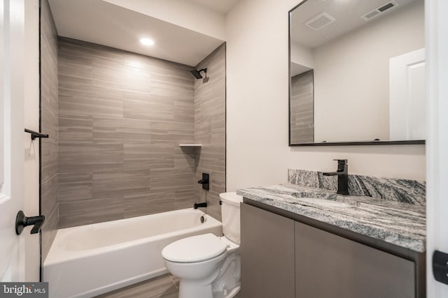 full bathroom featuring toilet, washtub / shower combination, and vanity