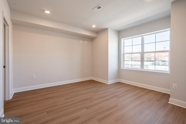 unfurnished room with light wood finished floors, baseboards, and recessed lighting