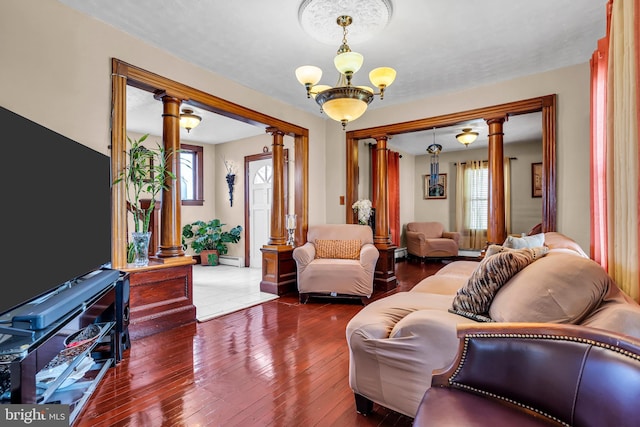 living room featuring decorative columns, healthy amount of natural light, a chandelier, and baseboard heating