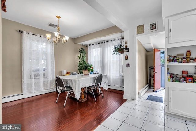 dining area featuring a chandelier, a baseboard radiator, and light wood-style flooring