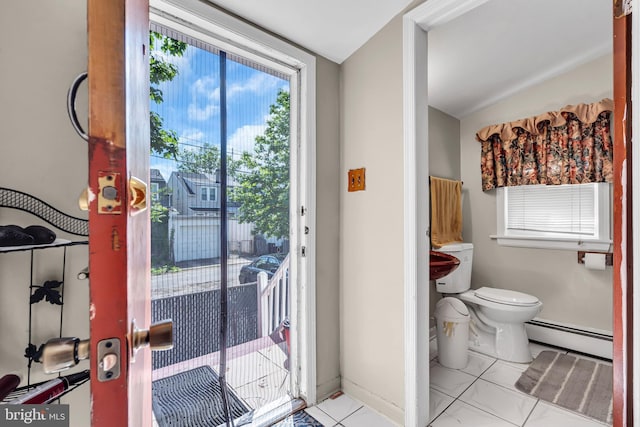 doorway to outside with a baseboard radiator, tile patterned floors, and vaulted ceiling