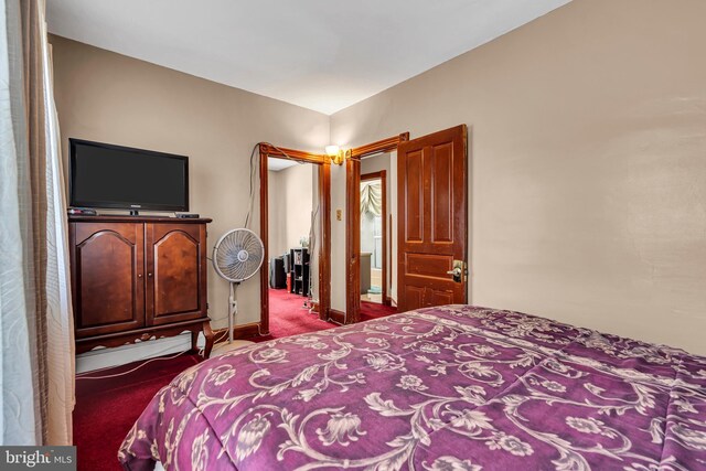 carpeted bedroom with a baseboard radiator and baseboards