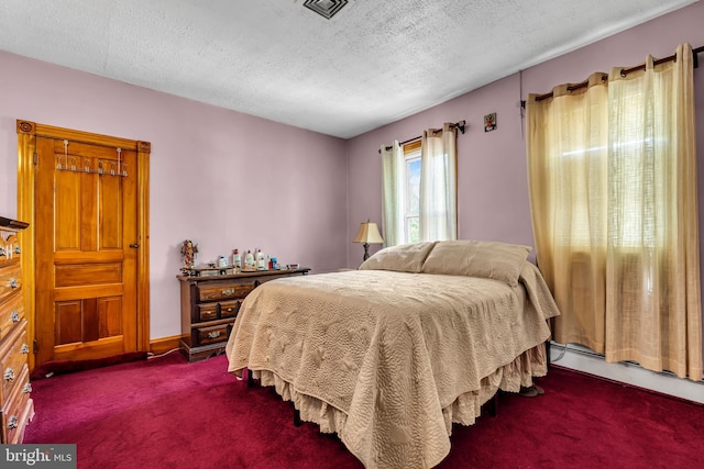 bedroom featuring dark colored carpet, a textured ceiling, and baseboard heating