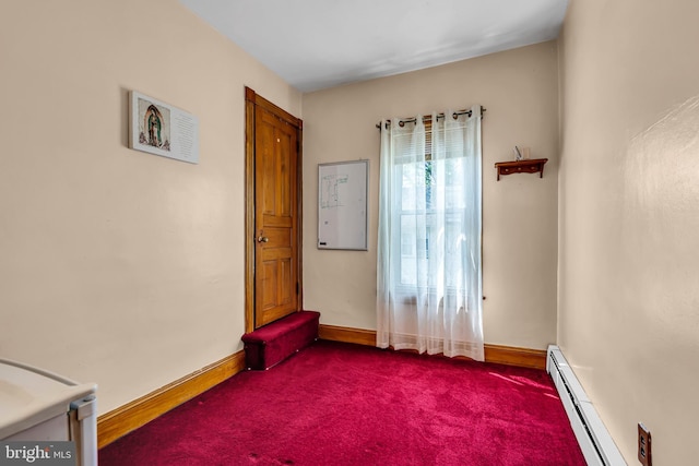 unfurnished room featuring a baseboard heating unit, baseboards, and dark colored carpet