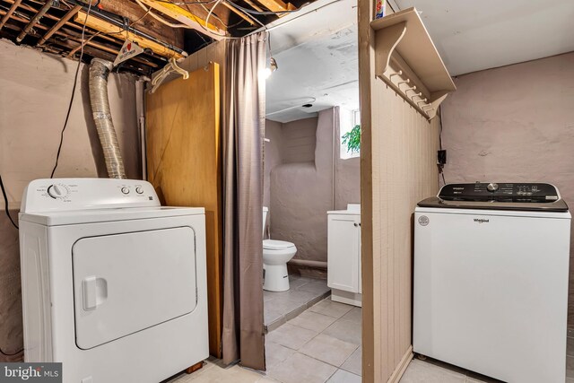 washroom with washing machine and dryer and light tile patterned floors