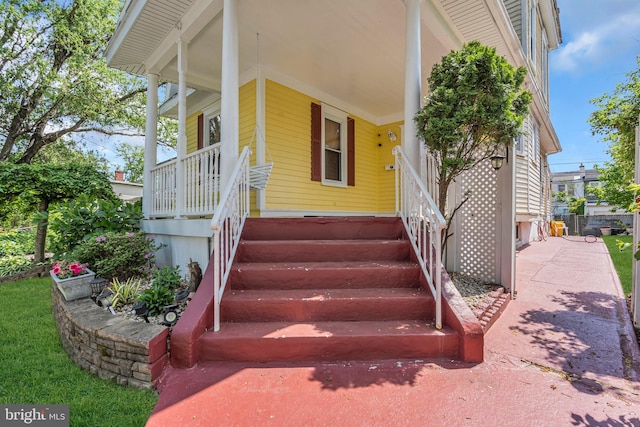 view of exterior entry featuring covered porch