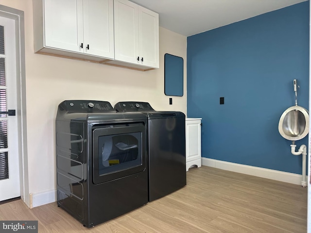 3406 Richmond St, Philadelphia, PA 19134 - laundry room with washing machine and clothes dryer, cabinet space, light wood-style flooring, and baseboards