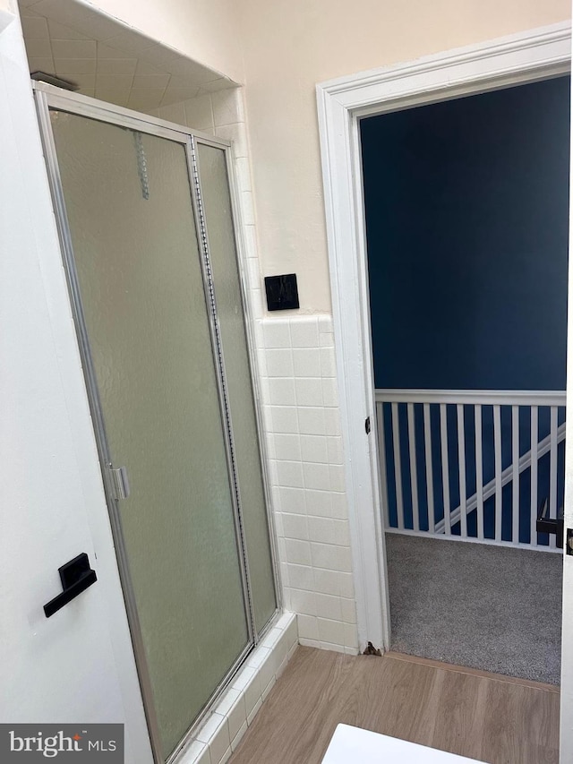 3406 Richmond St, Philadelphia, PA 19134 - full bath featuring wood finished floors, a stall shower, tile walls, and a wainscoted wall