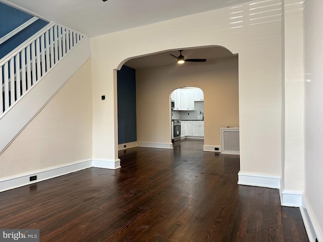 3406 Richmond St, Philadelphia, PA 19134 - unfurnished living room featuring ceiling fan, arched walkways, and dark wood-style floors