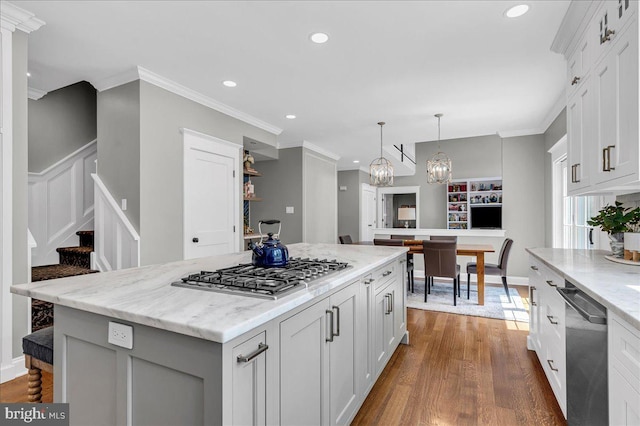 kitchen with stainless steel appliances, recessed lighting, a kitchen island, wood finished floors, and white cabinets