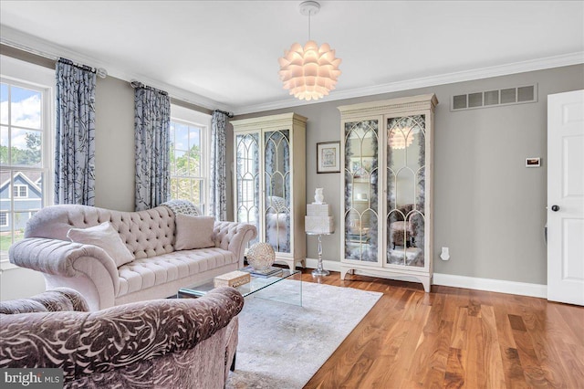 living area featuring baseboards, ornamental molding, and wood finished floors