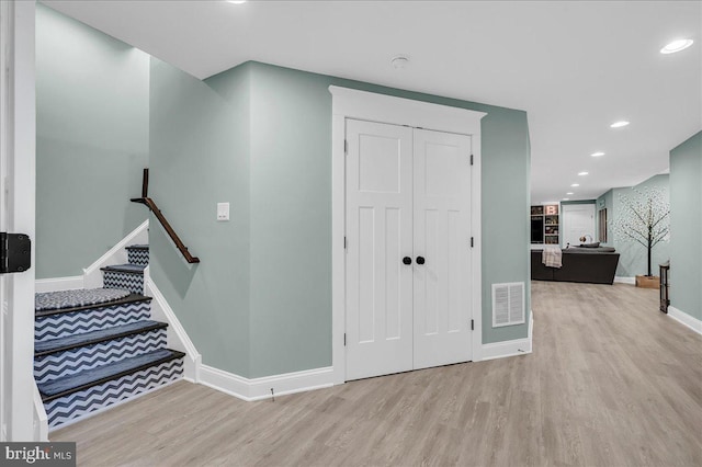 foyer with wood finished floors, baseboards, recessed lighting, and stairs