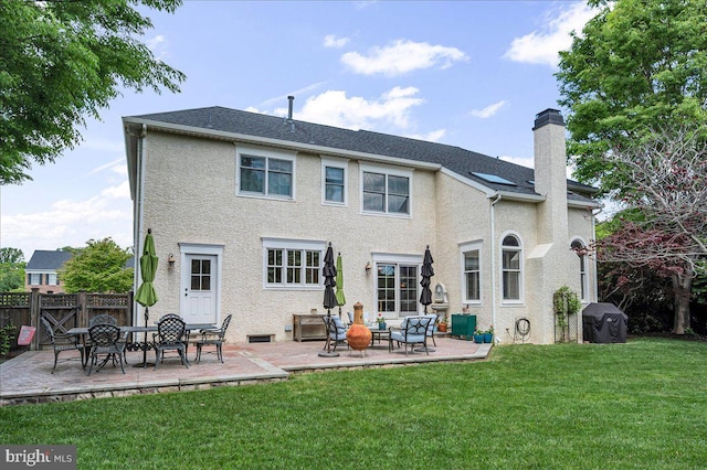 rear view of house featuring a chimney, a patio area, and stucco siding