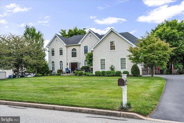 colonial inspired home with a front lawn