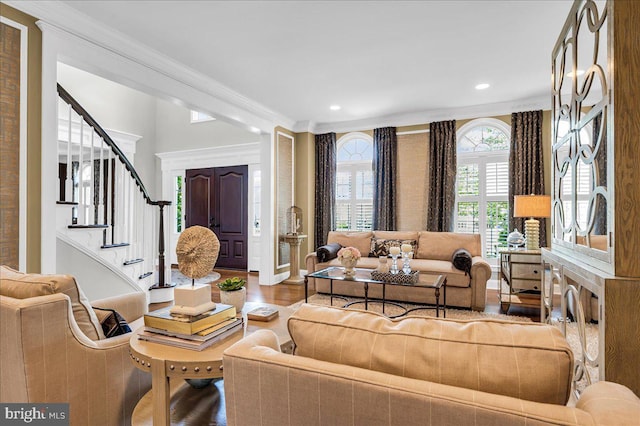 living room featuring wood finished floors, crown molding, stairway, and recessed lighting
